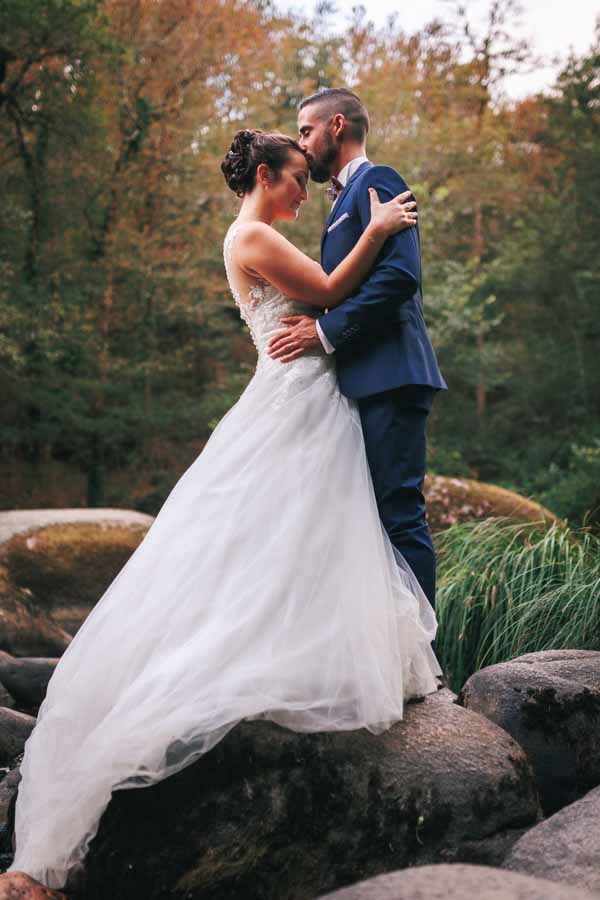Les mariés s'embrassent sur un rocher pour leurs photos de mariage à la Roche sur Yon en Vendée