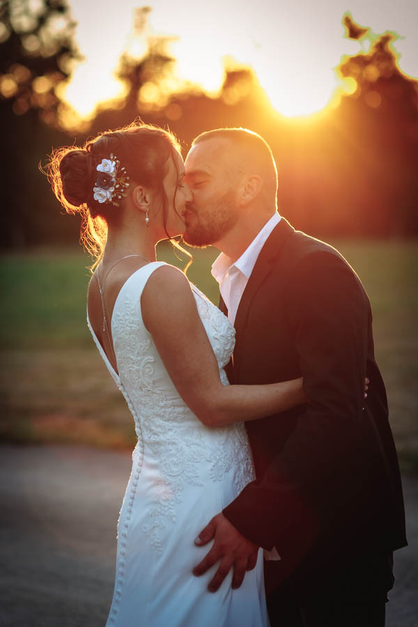 Les mariés s'embrassent au coucher du soleil pour les photos de leur mariage à la Roche sur Yon en Vendée