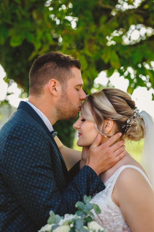 Un couple de mariés s'embrasse pour son photographe de mariage en Vendée