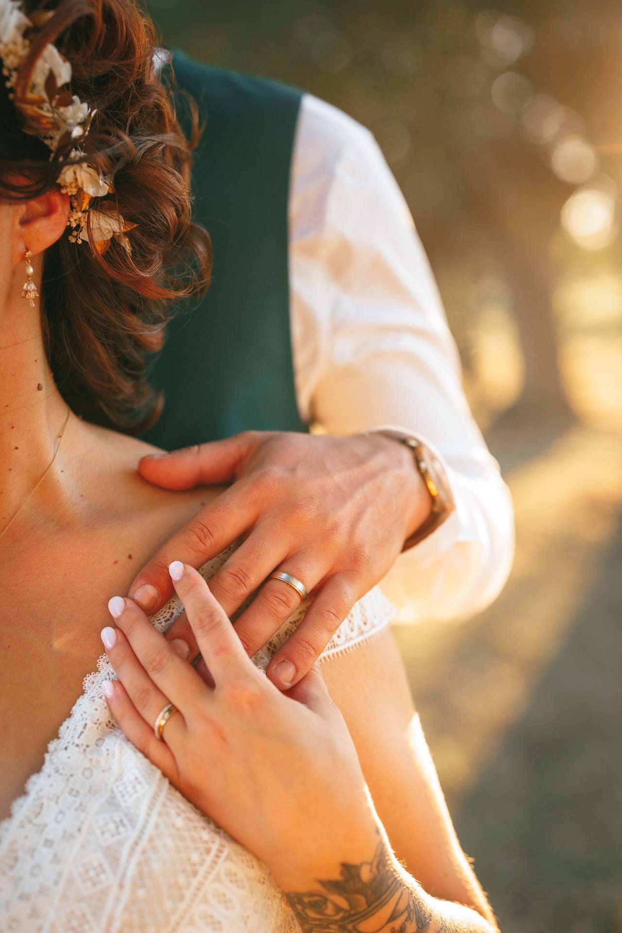 Photographie d'un Photographe de Mariage montrant les mains et les alliances d'un couple de marié lors de leur mariage en Vendée