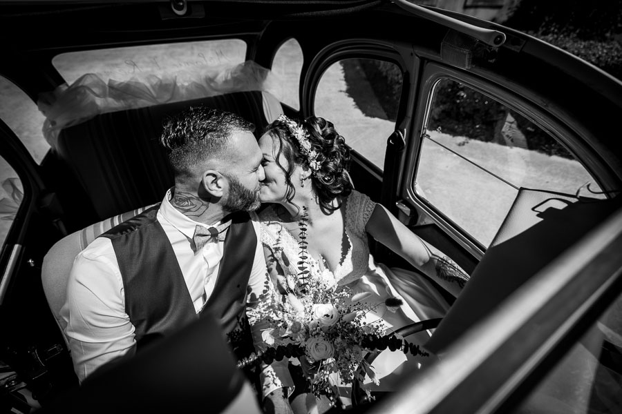 Les mariés s'embrassent dans une voiture lors d'un mariage au château de la Sébrandière en Vendée