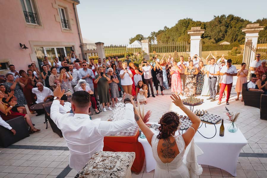 Les mariés mettent les bras en l'air devant les invités lors d'un mariage au château de la Sébrandière en Vendée
