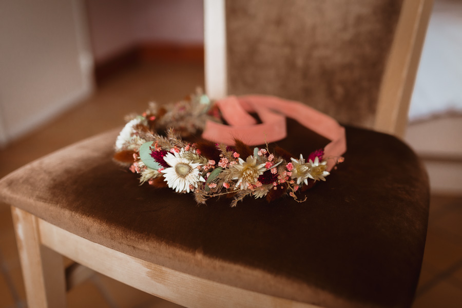 La couronne de fleur de la coiffure de la mariée est posée sur une chaise pour montrer l'organisation du mariage