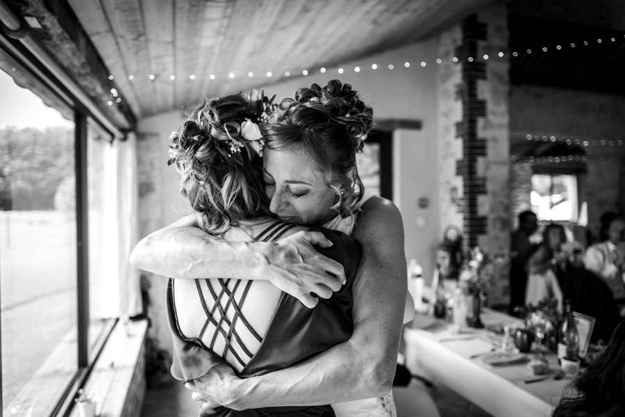 Photographie d'un photographe de mariage montrant une mariée qui fait un câlin à une invitée lors d'un mariage à Cholet