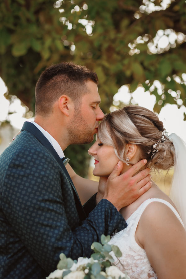 Photographie d'un Photographe de mariage montrant le marié qui embrasse la mariée pour leur mariage à la Rochelle