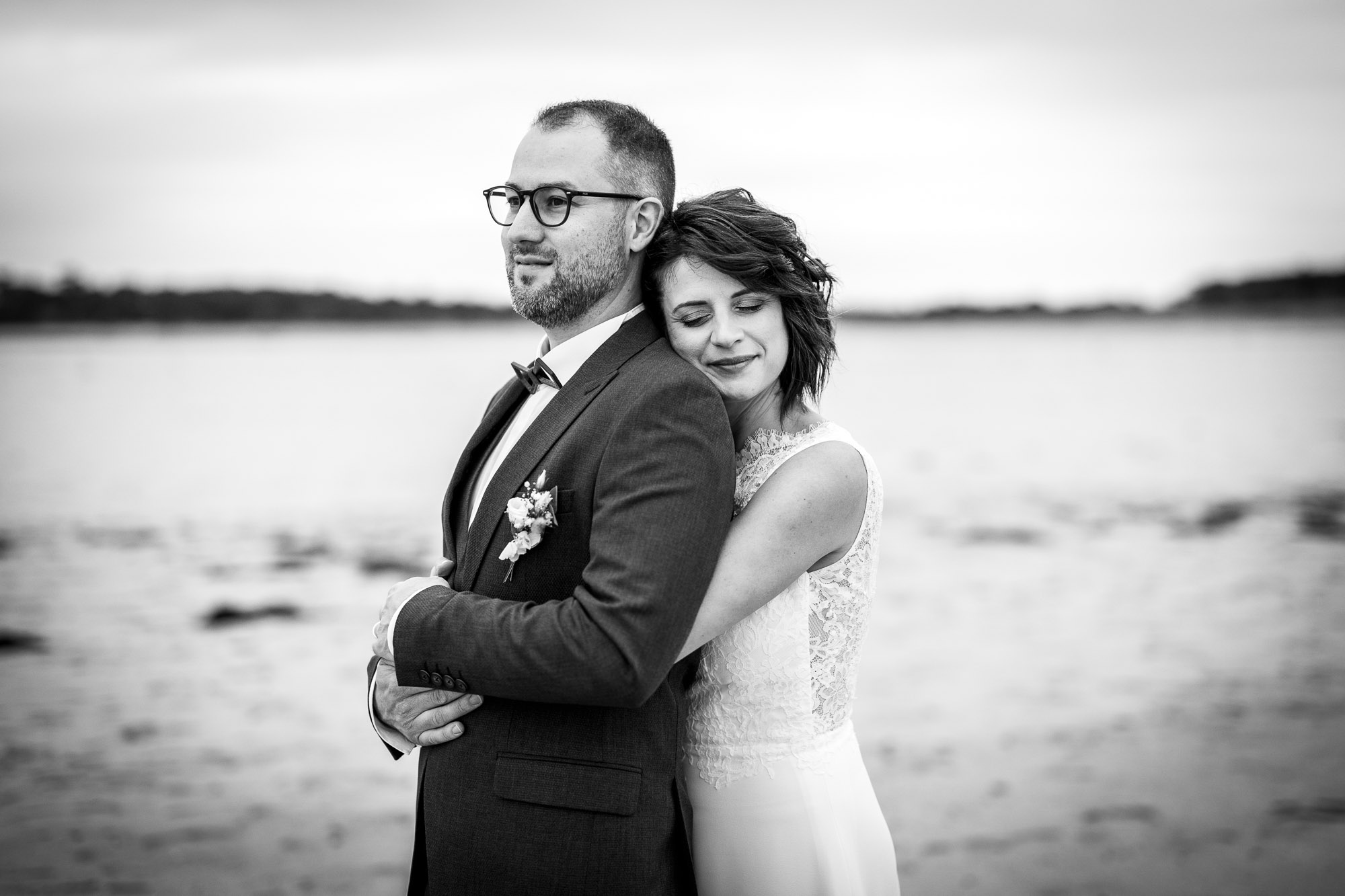 Photographie d'un photographe de mariage montrant une mariée qui serre le marié lors d'une séance de photos de couple de mariage en Vendée