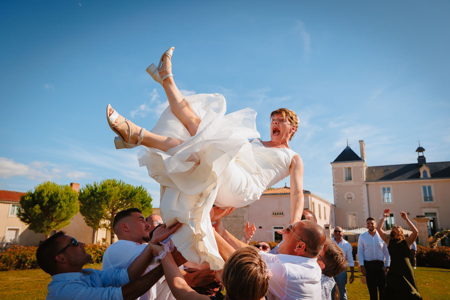 Photographie d'un photographe de mariage montrant une mariée qui saute dans les airs lors d'un mariage