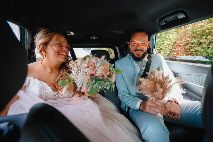 Les mariés s'embrassent dans une voiture lors d'un mariage au château de la Sébrandière en Vendée