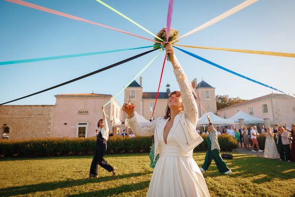 Photographie d'un Photographe de Mariage montrant une marié qui jour à la ronde des rubans lors d'un mariage en Vendée