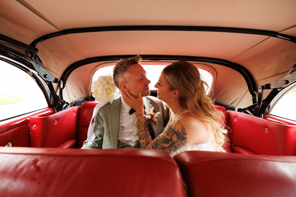 Les mariés s'embrassent dans une voiture lors d'un mariage au château de la Sébrandière en Vendée