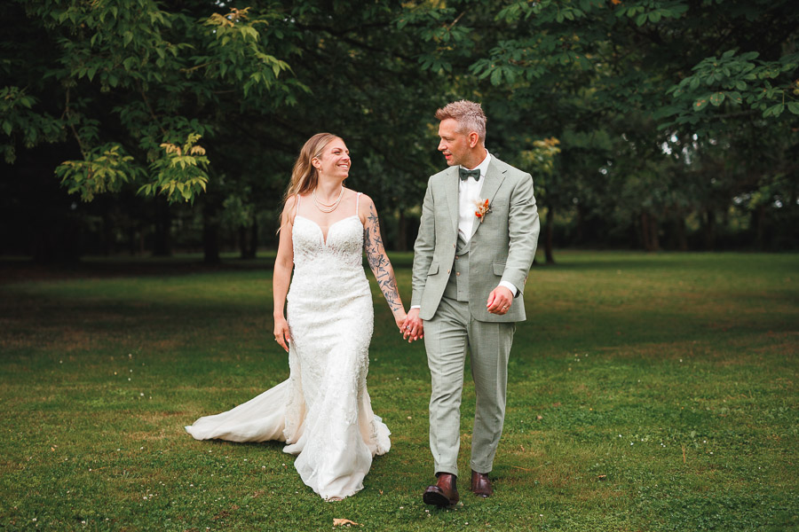 Les mariés marchent dans le parc du domaine pendant la séance de photos de couple de leur mariage - Photographe Vendée