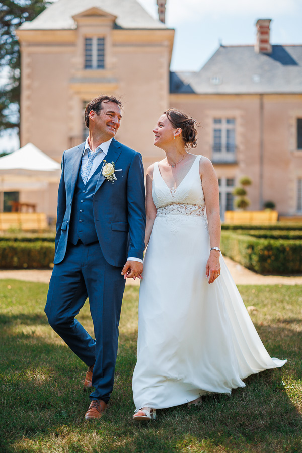 Les mariés marchent dans le parc du château  - Photographe mariage
