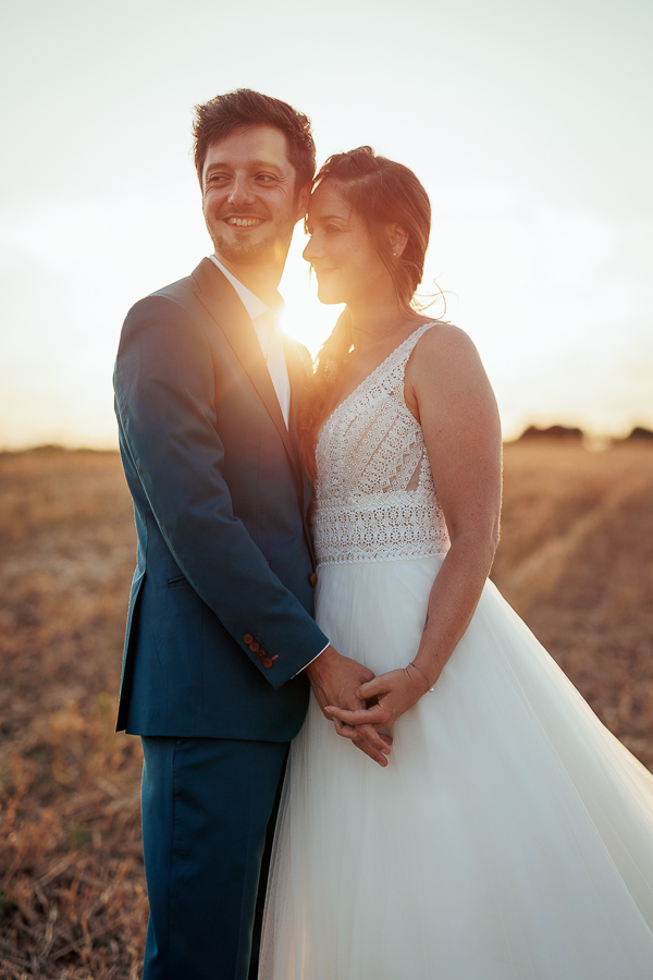 Les mariés posent au sunset dans un champ en Vendée, photographe portraot de mariage