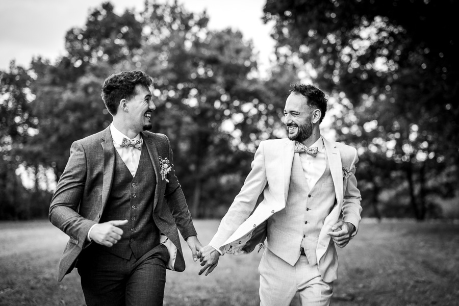 Les mariés courent dans la nature pour les photos de leur photographe de mariage en Vendée