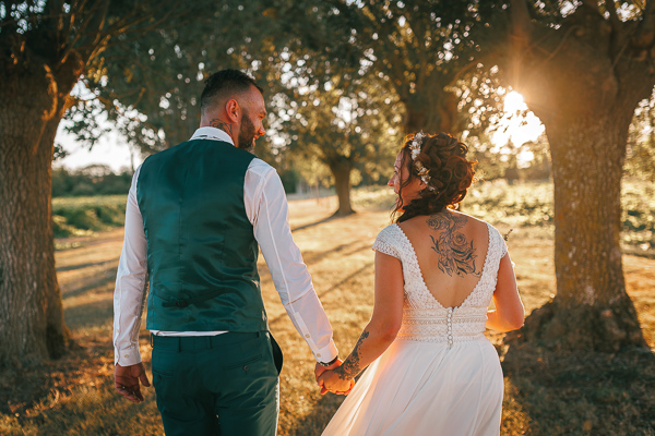 Les mariés marchent pour une balade romantique au coucher su soleil, photographe mariage Vendée