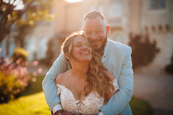 Les mariés sourient pour les photos de leur photographe de mariage en Vendée au soleil couchant