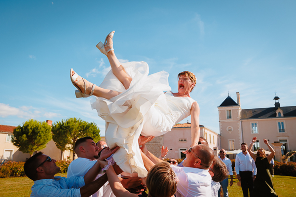 La mariée portée par les invités dans le jardin du château, animation captée par un photographe de mariage en Vendée